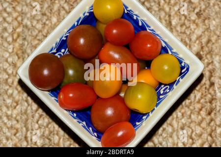 Quadratische Schüssel mit verschiedenen Farben von Cherry Tomaten gefüllt Stockfoto