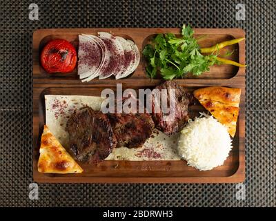 Mariniertes Rindfleisch Steak mit Reis geräuchertes Gemüse Zwiebelscheiben und Brot serviert Stockfoto