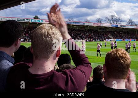 Cheltenham Town Fans applaudieren ihrem Team während des Warm Up. Cheltenham Town / FC Halifax in der Whaddon Road in der National League am 16. April 2016 Stockfoto