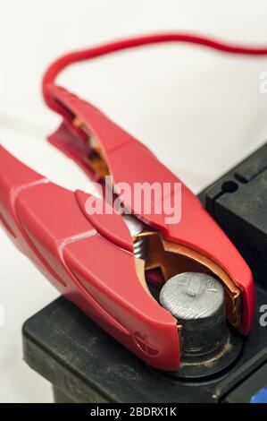 Laden der Autobatterie. Roter Kupferclip am Plus-Anschluss Stockfoto