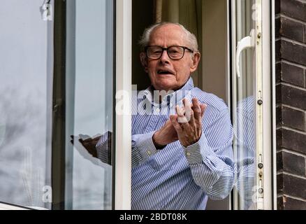 Harrogate, North Yorkshire, Großbritannien. April 2020. John Shannon, der 103 ist, kam aus seinem Fenster, um unsere NHS-Hauptarbeiter als Teil der Clap for Our Carers Initiative zu feiern. John wurde aufgrund seiner freiwilligen Arbeit in der Gemeinde, als er 101 war, mit dem Preis "Point of Light in Society" des Premierministers ausgezeichnet. Als Kriegsmarineoffizier half er, die belgische Sektion der Royal Navy zu gründen, und 2013 wurde er eingeladen, den ersten Stützpunkt der belgischen Marine zu eröffnen. Credit: ernesto rogata/Alamy Live News Stockfoto