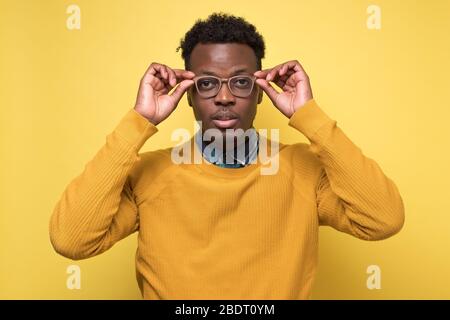 African american fröhlich zufrieden Kerl auf seine neue Brille Stockfoto