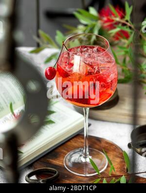 Ein Weinglas mit Kirschcocktail garniert mit Kirsche Stockfoto