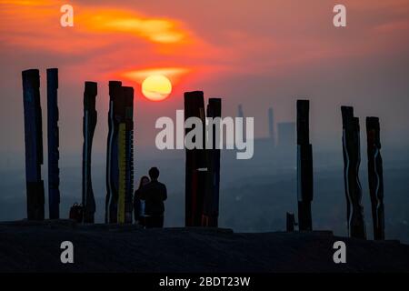 Der Schleuder Haniel, 185 Meter hoher Schlaghaufen, in der Grube Prosper Haniel, 2019 geschlossen, Kunstwerk Totems des Bildhauers Augustin Ibarrola, Sonnenuntergang Stockfoto