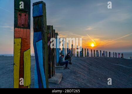 Der Schleuder Haniel, 185 Meter hoher Schlaghaufen, in der Grube Prosper Haniel, 2019 geschlossen, Kunstwerk Totems des Bildhauers Augustin Ibarrola, Sonnenuntergang Stockfoto