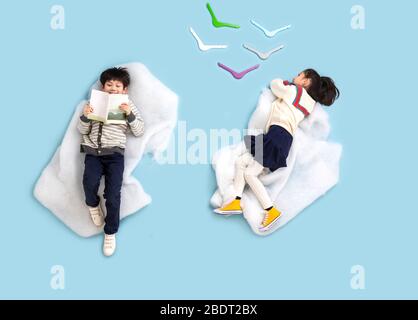 Fröhliches Kinderspiel zum Lesen auf der Wolke Stockfoto