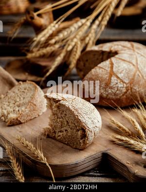 Bio-Brotscheibe auf Holzbrett in rustikalem Stil platziert Stockfoto