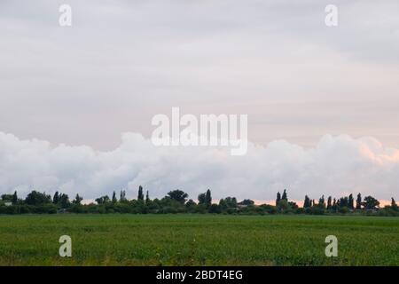 Landschaft trüb, das Dorf vor dem Regen, große Cumulus Wolken und Wolken über dem Dorf sichtbar. Stockfoto