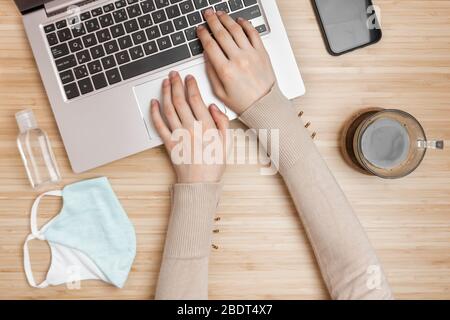 Draufsicht auf einem Handdesinfektionsmittel in der Nähe der Frauen Hände auf einer Tastatur. Coronavirus Prävention mit antibakteriellem Alkohol Gel auf einem Arbeitsplatz. Stockfoto
