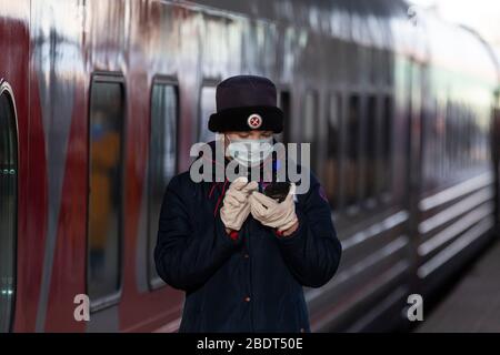 Moskau, Russland. April 2020 TRIFFT EIN Zugführer vor dem Abflug eines Zuges am Bahnhof Kazansky in Moskau während der Coronavirus COVID-19-Epidemie in Russland auf Passagiere Stockfoto