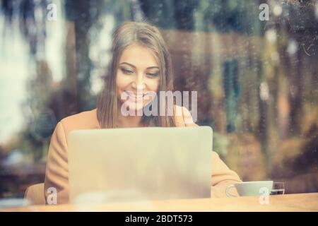 Geschäftsfrau, die Kaffee / Tee trinkt und Tablet-Computer in einem Café benutzt Stockfoto