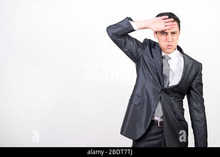 Müde Mann im Anzug, der mit der Handrückseite den Schweiß von der Stirn wischt. Auf weißem Hintergrund, mittlerer Schuss Stockfoto