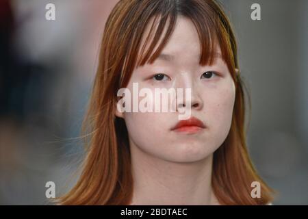 Chinesische junge Frau, die ernsthaft in der Jianghan Road, Wuhan, China aussieht Stockfoto