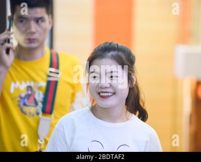 Chinesische junge Frau lächelt in der Jianghan Straße, Wuhan, China Stockfoto