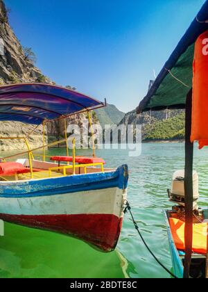 Komani See, ein Boot mit einem Baldachin auf dem Fluss. Flussboot. Ausflugsboot auf dem Fluss in Albanien. Stockfoto