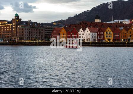 Ein beliebtes Touristenziel Bryggen in Bergen, Norwegen während der COVID-19-Epidemie leer. Ein Rotes Kreuz Charity Boot kann gesehen werden, das den Hafen verlässt. Stockfoto