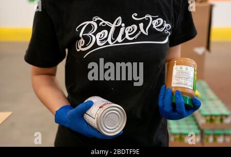 Washington, Vereinigte Staaten. April 2020. Ein Freiwilliger verpackt eine Schachtel Lebensmittel, die am 9. April 2020 in Washington, DC, an bedürftige Menschen in der Capital Area Food Bank verteilt werden sollen. Die Capital Area Food Bank bietet mit ihren gemeinnützigen Partnern in D.C., Maryland und Virginia mehr als 30 Millionen Mahlzeiten pro Jahr. Seit die pandemischen Lebensmittelbanken der COVID-19 im ganzen Land eine Nachfragesteigerung erlebt haben, da die Arbeitslosigkeit im ganzen Land Anstieg. Foto von Kevin Dietsch/UPI Credit: UPI/Alamy Live News Stockfoto