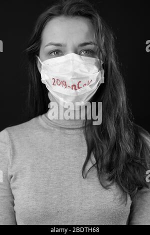 Porträt einer Frau Angst vor Coronavirus in medizinischer Maske mit 2019-ncov geschrieben Stockfoto