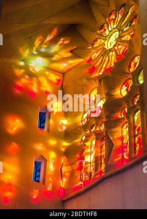 Das Innere der Basilika La Sagra Familia mit hellen Fenstern, die durch Buntglasfenster gefiltert werden. Stockfoto