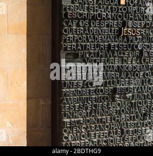 Bronzetür mit biblischem Text an der Passionsfassade der Basilika La Sagra Familia, Barcelona, Spanien . Stockfoto