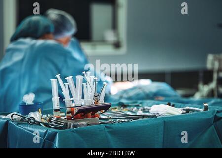 Chirurgische Instrumente im Operationssaal, auf einem sterilen Tisch auf einem speziellen blauen Gewebe angeordnet. Das Konzept von Medecine, Chirurgie, sterilen Bereich Stockfoto