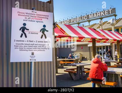 Vancouver, Kanada - 7. Apr 2020: Öffentlichkeit sitzt im Freien auf dem Granville Island Public Market im Innenhof während der Coronavirus-Pandemie Stockfoto