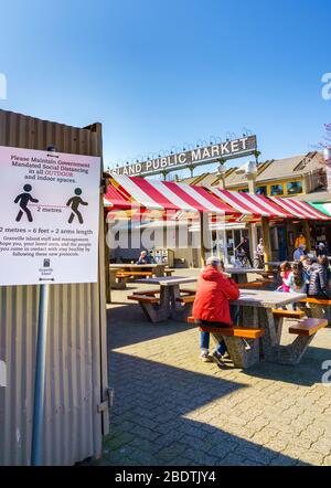 Vancouver, Kanada - 7. Apr 2020: Öffentlichkeit sitzt im Freien auf dem Granville Island Public Market im Innenhof während der Coronavirus-Pandemie Stockfoto