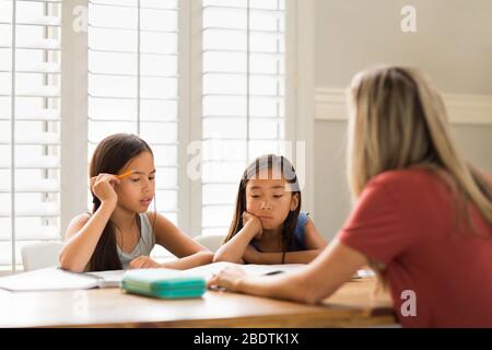 Mutter Hilft Ihren Töchtern Bei Ihren Hausaufgaben Stockfoto