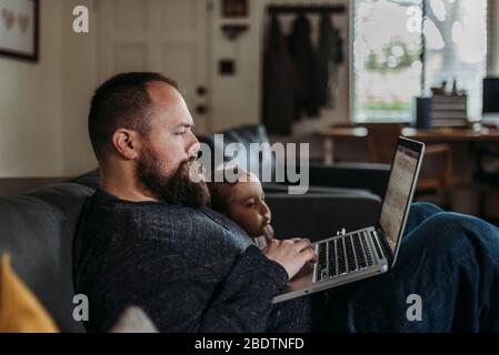 Nahaufnahme von Papa arbeitet von zu Hause mit jungen Tochter Stockfoto