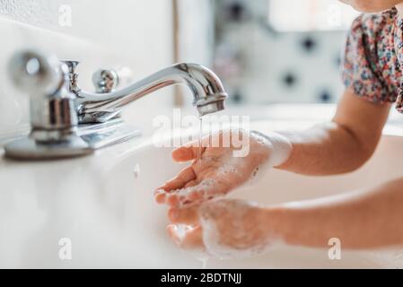 Nahaufnahme des kleinen Kindes, das die Hände mit Seife im Waschbecken wäscht Stockfoto