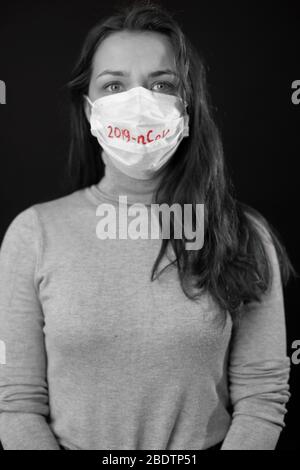 Porträt einer Frau Angst vor Coronavirus in medizinischer Maske mit 2019-ncov geschrieben Stockfoto