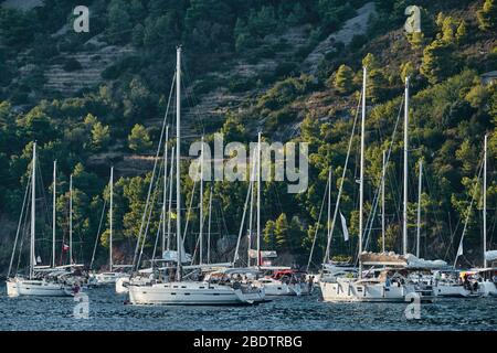 Ist eine Menge Segelboote in Marina in Kroatien bei Sonnenuntergang, Insel mit grünen Bäumen sind auf dem Hintergrund, ist in der Nähe der Stadt Vis Stockfoto