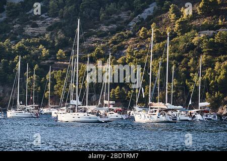 Ist eine Menge Segelboote in Marina in Kroatien bei Sonnenuntergang, Insel mit grünen Bäumen sind auf dem Hintergrund, ist in der Nähe der Stadt Vis Stockfoto