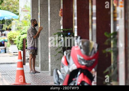 Bangkok, Thailand. April 2020. Ein Obdachloser, der eine Gesichtsmaske trägt, um die Ausbreitung des Coronavirus zu verhüten, bittet in Bangkok um Geld.Thailand hat bisher 2,423 Fälle von COVID-19 Coronavirus gemeldet, wobei die meisten Fälle in der Hauptstadt Bangkok gemeldet wurden. Kredit: Amphol Thongmueangluang/SOPA Images/ZUMA Wire/Alamy Live News Stockfoto