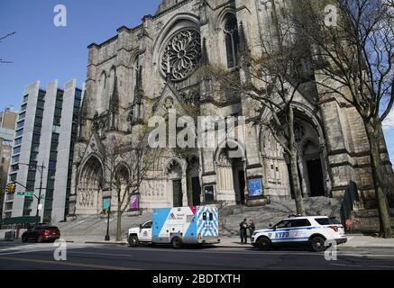 New York, Usa. April 2020. Am Donnerstag, den 9. April 2020, werden ein Krankenwagen und ein Polizeiauto der NYPD vor der Episcopal Cathedral of St. John the Divine in New York City geparkt. St. John the Divine eine der ikonischsten Kathedralen der Welt hatte Pläne, in ein Feldkrankenhaus in Manhattan umgewandelt zu werden, aber das Mount Sinai Health System entschied sich, diese Pläne zu diesem Zeitpunkt nicht zu verfolgen. Die Zahl der Todesopfer von COVID-19 in New York City nähert sich 5,000. Foto von John Angelillo/UPI Quelle: UPI/Alamy Live News Stockfoto