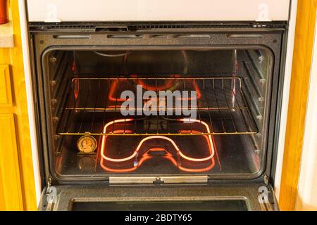 Im Inneren eine Konvektion Spulen Elektro-Backofen mit voller Energie, Heizung, Ofen Lichter und Kochen Regal. Stockfoto