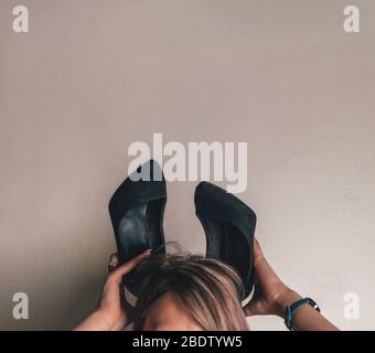 Schuhe auf dem Kopf der Blondine Stockfoto