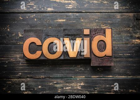 Das Wort 'COVID' in Vintage Holz Buchdruck auf einem rustikalen Hintergrund geschrieben. Stockfoto