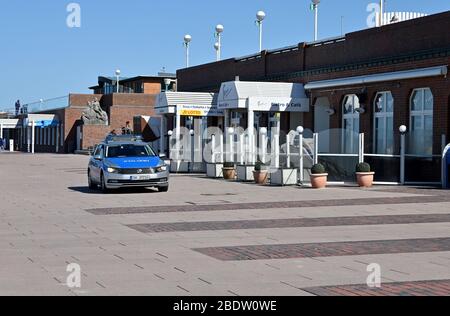 Westerland, Deutschland. April 2020. Ein Polizeiauto fährt die fast menschenleere Promenade entlang. (Zu dpa 'IT's a Disaster' - EIN Besuch auf dem isolierten Sylt) Quelle: Carsten Rehder/dpa/Alamy Live News Stockfoto