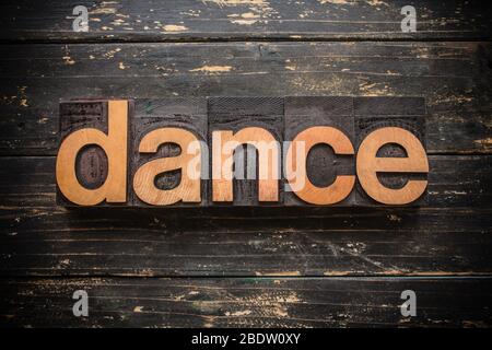 Das Wort 'DANCE' in Vintage Holz Buchdruck geschrieben auf einem rustikalen Hintergrund. Stockfoto