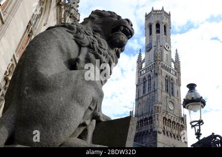 Glockenturm von Brügge Turm auf dem Marktplatz mit einer Löwen-Statue in froegground.Bruges.West Flandern.Belgien Stockfoto