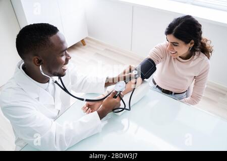 In der Nähe von Doktor Messen Patienten Blutdruck mit Stethoskop Stockfoto