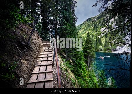 Schöne Sicht auf die Berge und den See Kolsai Walking Bridge in der Nähe von Tannen in Kasachstan und Zentralasien Stockfoto