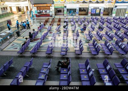 BANGKOK, THAILAND: Ein Mann sitzt allein in einem Wartebereich in Hua Lamphong, Bangkok Railway Station, wo Stühle mit XS markiert wurden, damit Menschen inmitten der COVID-19 Coronavirus Ängste am 6. April 2020 in Thailand soziale Distanz üben können. Stockfoto