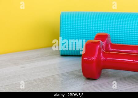 Yogamatte und rosa Hantel - Corona Virus Covid - 19 Lock down, eingeschränkte Bewegung und Workout-Trainingskonzept. Stockfoto