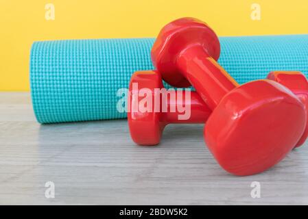 Yogamatte und rosa Hantel - Corona Virus Covid - 19 Lock down, eingeschränkte Bewegung und Workout-Trainingskonzept. Stockfoto