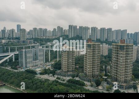 Chongqing, China - 19. Dez 2019: Luftdrohne schoss von überfüllten Wohngebäuden am Flussufer mit Überflug am Yangtze Fluss Stockfoto