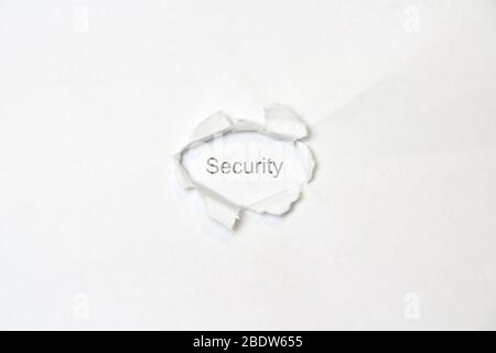 Word Security auf weißem, isoliertem Hintergrund, die Inschrift durch das gewickelte Loch im Papier. Stock Foto für Web und Print mit leerem Raum für Text und Design. Stockfoto