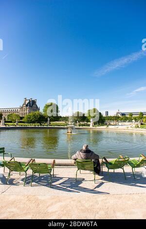 Paris. Frankreich - 15. Mai 2019: Der einsame Mann sitzt und entspannt auf einem Stuhl im Tuileries-Garten. Stockfoto