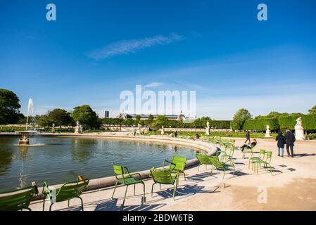 Paris. Frankreich - 15. Mai 2019: Die Leute sitzen und entspannen auf einem Stuhl neben Brunnen in Tuileries Garten. Stockfoto